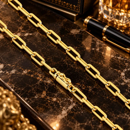 Detalhe em aproximação da corrente estilo Cartier banhada a ouro 18k destacando o fecho canhão reforçado com trava de segurança em bancada luxuosa.