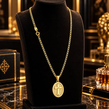 Colar masculino banhado a ouro 18k com corrente grumet e medalha oval com cruz detalhada em alto relevo exibido em um busto expositor de joias preto.