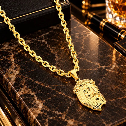 Colar masculino banhado a ouro 18k com corrente modelo cadeado e pingente grande com a Face de Cristo sobre bancada de mármore escura.