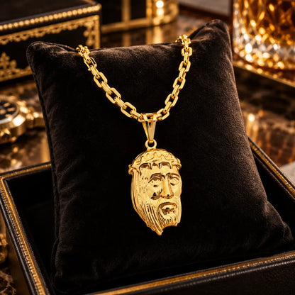 Pingente grande em alto relevo com a Face de Cristo e Corrente Cadeado banhados a ouro 18k dispostos sobre uma almofada de veludo preto.