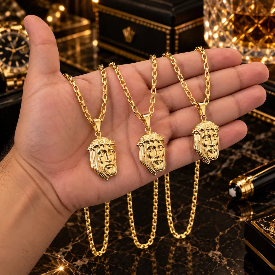 Mão masculina segurando três colares de corrente cadeado com pingente grande Face de Cristo banhados a ouro 18k para comparação de proporção