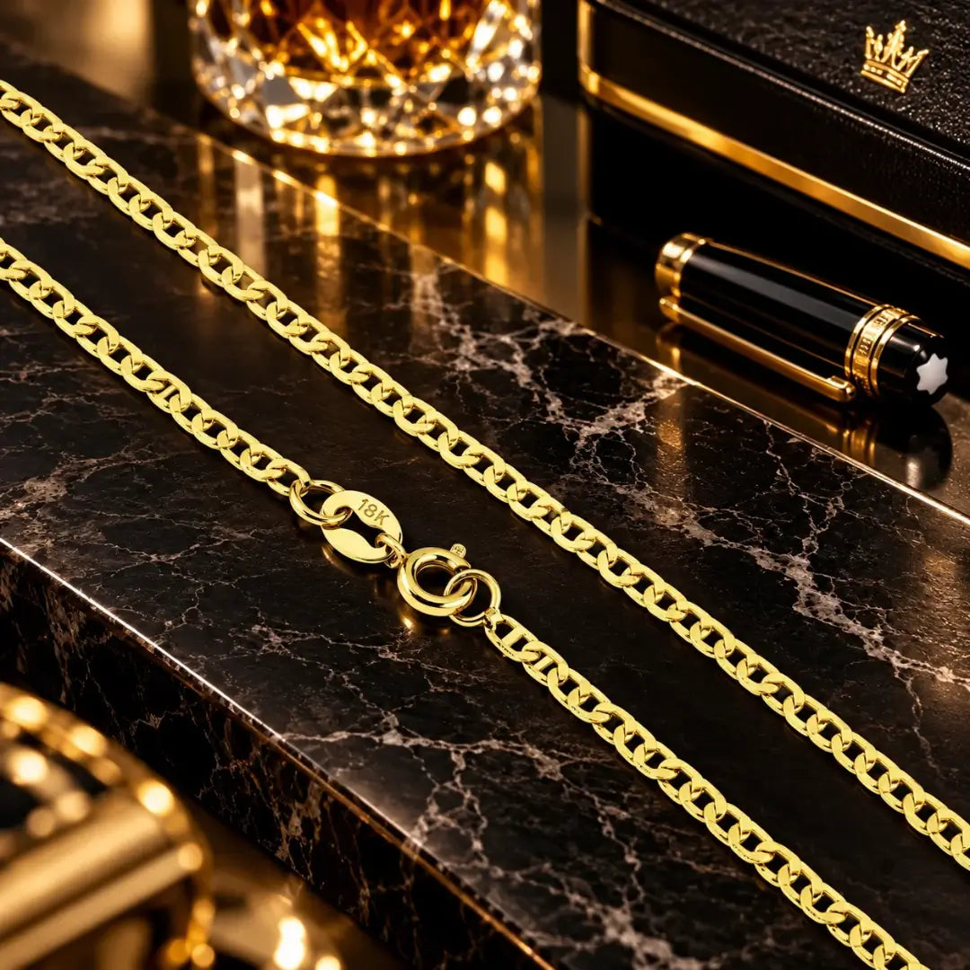 Detalhe em aproximação da corrente piastrini banhada a ouro 18k destacando o fecho boia com gravação de autenticidade 18K sobre bancada de mármore escura.
