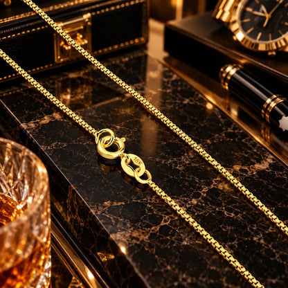 Detalhe em aproximação do fecho boia com timbre 18K e dos elos alinhados da corrente veneziana masculinas banhados a ouro 18k.