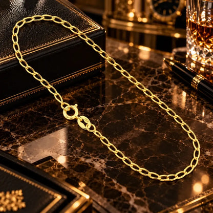 Vista superior da pulseira masculina banhada a ouro 18k com elos grumet longos de 2.5mm e fecho boia estendida sobre superfície de mármore luxuosa.